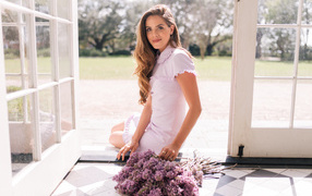 Beautiful girl in a dress with a bouquet of lilacs