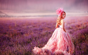 Красивая девушка в розовом платье гуляет по лавандовому полю