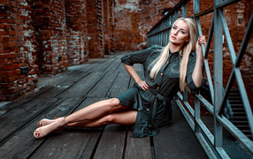 Красивая девушка сидит на деревянном полу