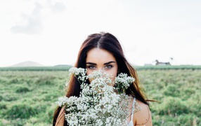 Красивая девушка с букетом полевых цветов