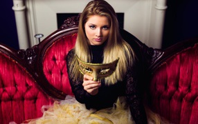 Красивая девушка с маской в руках