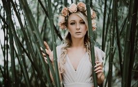Красивая девушка с венком на голове в зарослях бамбука