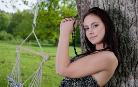 Beautiful girl with black beads under a tree