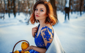 Beautiful girl with pears in a snowy forest