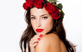 Красивая девушка с красными губами с венком из роз на голове