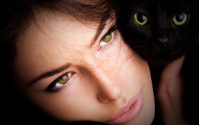 Красивая зеленоглазая девушка с черной кошкой