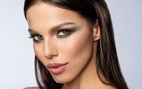 Красивая зеленоглазая девушка с макияжем на лице