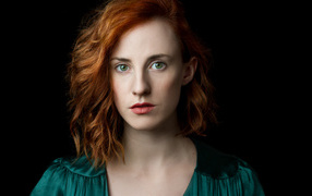 Красивая зеленоглазая рыжеволосая девушка на черном фоне 