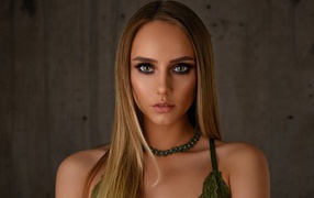 Красивая длинноволосая блондинка с украшением на шее 