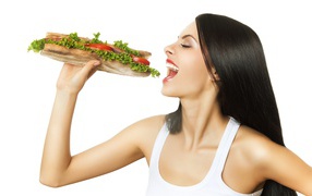 Красивая длинноволосая девушка брюнетка с большим бутербродом 