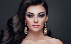 Beautiful long-haired girl with bright makeup and long earrings