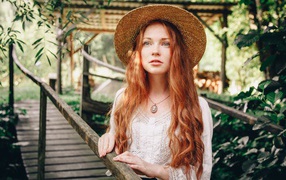 Красивая рыжеволосая девушка в соломенной шляпе
