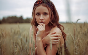Beautiful red-haired girl on a field with wheat