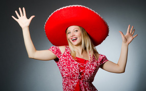 Красивая улыбающаяся блондинка в большой красной шляпе
