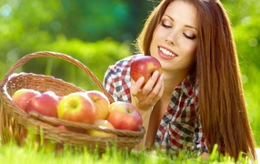 Красивая улыбающаяся девушка с корзиной красных яблок