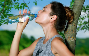 Красивая спортивная девушка с бутылкой воды