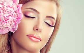 Красивая нежная молодая девушка с розовым цветком пиона в волосах 