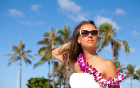 Красивая молодая девушка в солнечных очках на тропическом пляже