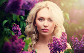 Blue-eyed blonde in lilac branches