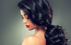 Девушка брюнетка с красивыми волосами на сером фоне