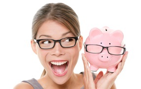 Веселая девушка в очках с копилкой в руках на белом фоне