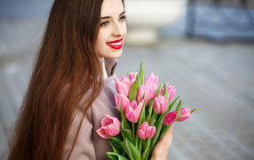 Gentle smiling girl with a brown-haired woman with a bouquet of tulips
