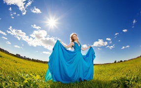 Girl in a beautiful blue dress against the sky