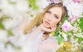Green-eyed girl in the flowers of the rose