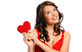 Улыбающаяся девушка с красным сердечком в руках на белом фоне