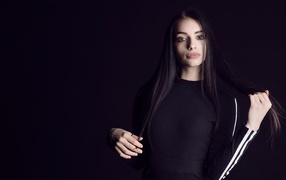Эффектная брюнетка в черном наряде на черном фоне