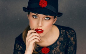 Стильная девушка с ярким макияжем в черной шляпе 