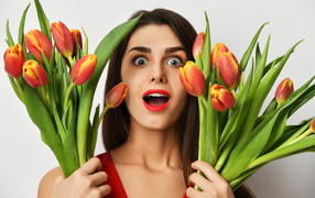 Удивленная шатенка с букетами тюльпанов