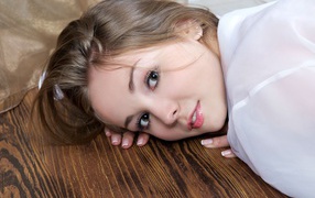 Нежная девушка шатенка лежит на полу