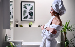 Young girl in a bathrobe and with a towel in the bathroom