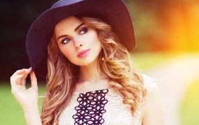 Молодая девушка в большой черной шляпе