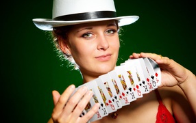 Young girl in a hat with cards in hands