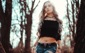 Молодая девушка в рваных джинсах с пирсингом в носу