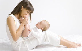 Молодая девушка в белом с младенцем