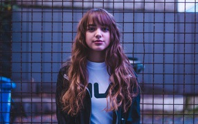 Молодая девушка на фоне железной сетки