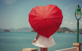 Молодая девушка с красным зонтом в форме сердца