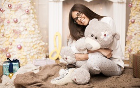 Young girl with glasses with a teddy bear