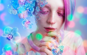 Молодая девушка с розовым макияжем в окружении цветов