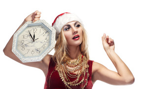 Bright girl in a New Year's suit with a clock in her hand on a white background