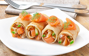 Rolls of pancakes with fish and cucumbers for carnival
