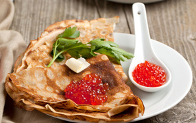 Ruddy thin pancakes with red caviar on Pancake week