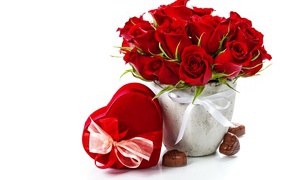 Коробка с конфетами в форме сердца и букет красных роз на белом фоне на День Влюбленных 14 февраля