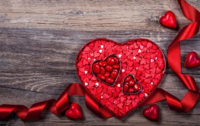 Коробка конфет в форме сердца с красной лентой в подарок