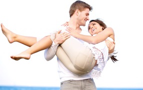 Влюбленный парень держит девушку на руках