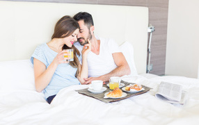 Влюбленная пара с завтраком в постели