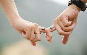 Руки влюбленной пары с татуировками на руках 